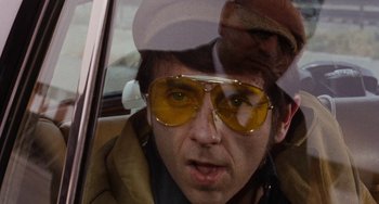 Movie still from “Easy Rider” (1969), directed by Dennis Hopper – A man wearing sunglasses and a hat in a car; Close Up shot, Low angle