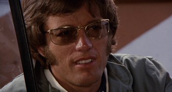 Movie still from “Easy Rider” (1969), directed by Dennis Hopper – A person wearing glasses; Close Up shot, Low angle