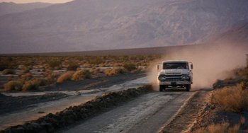 Movie still from “Easy Rider” (1969), directed by Dennis Hopper – A truck driving down a dirt road in the middle of the desert; Extreme Wide shot, Low angle