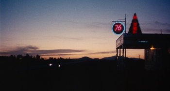 Movie still from “Easy Rider” (1969), directed by Dennis Hopper – A gas station sign with the sky in the background at dusk; Extreme Wide shot, Low angle