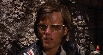 Movie still from “Easy Rider” (1969), directed by Dennis Hopper – A person wearing sunglasses and a leather jacket; Close Up shot, Low angle