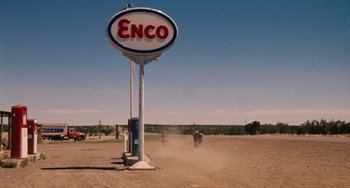 Movie still from “Easy Rider” (1969), directed by Dennis Hopper – An enco gas station sign in the middle of a dirt field; Extreme Wide shot, Low angle
