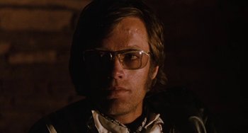 Movie still from “Easy Rider” (1969), directed by Dennis Hopper – A person wearing glasses and a jacket; Close Up shot, Low angle