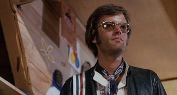 Movie still from “Easy Rider” (1969), directed by Dennis Hopper – A man wearing a neck tie and a jacket; Close Up shot, Low angle