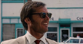Movie still from “Easy Rider” (1969), directed by Dennis Hopper – A person wearing a suit and sunglasses; Close Up shot, Low angle