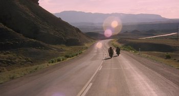 Movie still from “Easy Rider” (1969), directed by Dennis Hopper – Two people riding motorcycles down the middle of a road; Extreme Wide shot, Low angle