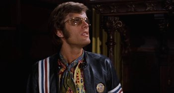 Movie still from “Easy Rider” (1969), directed by Dennis Hopper – A man wearing a leather jacket and sunglasses looking to his left; Close Up shot, Low angle