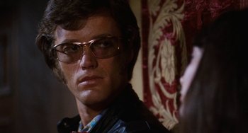 Movie still from “Easy Rider” (1969), directed by Dennis Hopper – A person wearing glasses and a leather jacket; Close Up shot, Over the shoulder angle