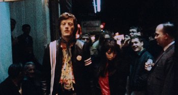 Movie still from “Easy Rider” (1969), directed by Dennis Hopper – A group of people walking down a street at night; Medium shot, Low angle