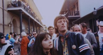 Movie still from “Easy Rider” (1969), directed by Dennis Hopper – A man and a woman standing next to each other in a crowd; Medium shot, Low angle