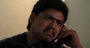 Movie still from “El Mariachi” (1992), directed by Robert Rodriguez – A person talking on a cell phone; Close Up shot, Low angle