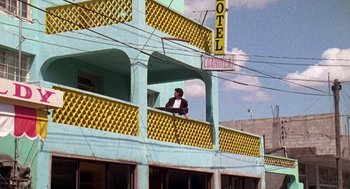 Movie still from “El Mariachi” (1992), directed by Robert Rodriguez – A man standing on the balcony of a hotel; Wide shot, Low angle