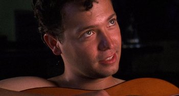 Movie still from “El Mariachi” (1992), directed by Robert Rodriguez – A man's face with a guitar; Close Up shot, High angle