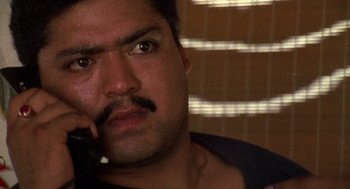 Movie still from “El Mariachi” (1992), directed by Robert Rodriguez – A person holding a cell phone to their ear; Close Up shot, Low angle