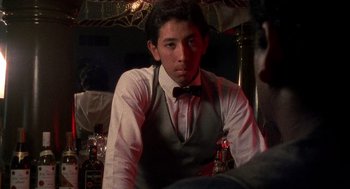 Movie still from “El Mariachi” (1992), directed by Robert Rodriguez – A man in a bow tie sitting in front of a table; Close Up shot, Low angle