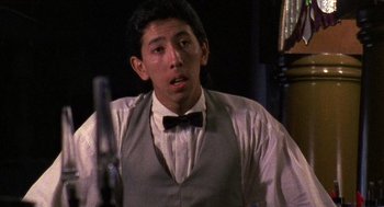 Movie still from “El Mariachi” (1992), directed by Robert Rodriguez – A man in a bow tie and a gray vest; Close Up shot, Low angle