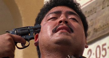 Movie still from “El Mariachi” (1992), directed by Robert Rodriguez – A person with a gun on his head; Extreme Close Up shot, Low angle