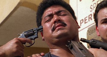 Movie still from “El Mariachi” (1992), directed by Robert Rodriguez – A man is holding a gun up to his face; Close Up shot, High angle
