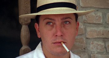 Movie still from “El Mariachi” (1992), directed by Robert Rodriguez – A person wearing a hat smoking a cigarette; Close Up shot, Low angle