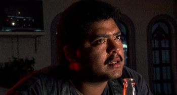 Movie still from “El Mariachi” (1992), directed by Robert Rodriguez – A person holding a bottle of beer; Close Up shot, Low angle