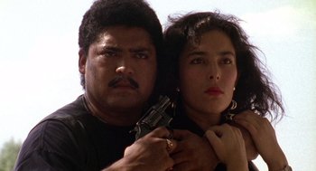 Movie still from “El Mariachi” (1992), directed by Robert Rodriguez – A man and a woman are holding a gun; Close Up shot, Low angle