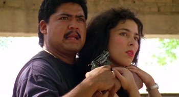 Movie still from “El Mariachi” (1992), directed by Robert Rodriguez – A man and a woman are holding guns; Close Up shot, Low angle