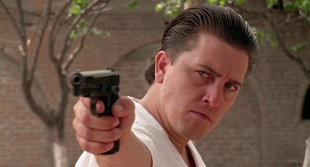 Movie still from “El Mariachi” (1992), directed by Robert Rodriguez – A man holding a gun pointed at the camera; Close Up shot, Low angle