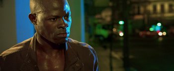 Movie still from “Elephant White” (2011), directed by Prachya Pinkaew – A person wearing a black shirt; Close Up shot, Low angle