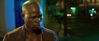 Movie still from “Elephant White” (2011), directed by Prachya Pinkaew – A person wearing a brown jacket; Close Up shot, Low angle