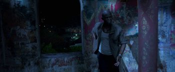 Movie still from “Elephant White” (2011), directed by Prachya Pinkaew – A man standing next to a wall at night; Medium shot, High angle