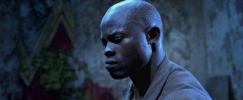 Movie still from “Elephant White” (2011), directed by Prachya Pinkaew – A man with blue hair is looking to his left; Close Up shot, Low angle