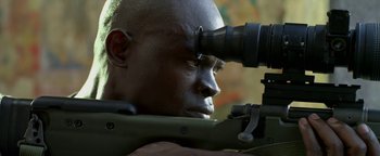 Movie still from “Elephant White” (2011), directed by Prachya Pinkaew – A man looking through a scope on a rifle; Close Up shot, Over the shoulder angle