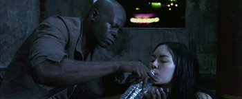 Movie still from “Elephant White” (2011), directed by Prachya Pinkaew – A man and a woman drinking water from a water bottle; Close Up shot, Low angle