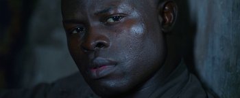 Movie still from “Elephant White” (2011), directed by Prachya Pinkaew – A man's face with black paint on it's face; Extreme Close Up shot, Low angle