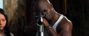 Movie still from “Elephant White” (2011), directed by Prachya Pinkaew – A man is looking through a rifle scope; Close Up shot, High angle