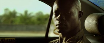 Movie still from “Elephant White” (2011), directed by Prachya Pinkaew – A person sitting in a car; Close Up shot, Low angle