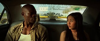 Movie still from “Elephant White” (2011), directed by Prachya Pinkaew – A man and a woman sitting in the back of a car; Close Up shot, Over the shoulder angle