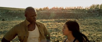 Movie still from “Elephant White” (2011), directed by Prachya Pinkaew – A man and a woman standing on a dirt field; Close Up shot, Low angle