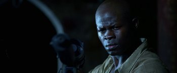 Movie still from “Elephant White” (2011), directed by Prachya Pinkaew – A man with a gun in his hand; Close Up shot, Low angle