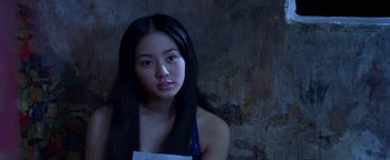 Movie still from “Elephant White” (2011), directed by Prachya Pinkaew – A woman with long black hair wearing a white apron; Close Up shot, Low angle