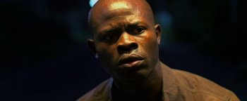 Movie still from “Elephant White” (2011), directed by Prachya Pinkaew – A man's face in the dark; Close Up shot, Low angle