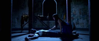Movie still from “Elephant White” (2011), directed by Prachya Pinkaew – A man and a woman laying on the ground; Wide shot, Overhead angle