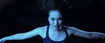 Movie still from “Elephant White” (2011), directed by Prachya Pinkaew – A beautiful young woman with a black feather in her hair; Close Up shot, Low angle