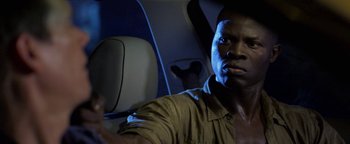 Movie still from “Elephant White” (2011), directed by Prachya Pinkaew – A man sitting in the back seat of a car; Close Up shot, Over the shoulder angle