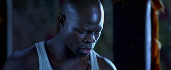 Movie still from “Elephant White” (2011), directed by Prachya Pinkaew – A man with a bald head is looking down at his face; Close Up shot, Low angle