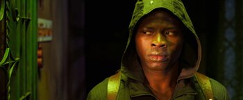 Movie still from “Elephant White” (2011), directed by Prachya Pinkaew – A man in a green jacket and a green hood; Close Up shot, Over the shoulder angle