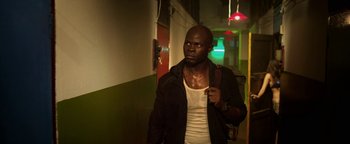 Movie still from “Elephant White” (2011), directed by Prachya Pinkaew – A man in a white shirt and a black jacket; Medium shot, Low angle