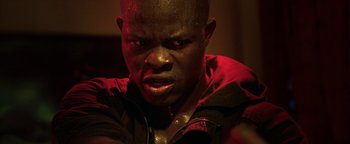 Movie still from “Elephant White” (2011), directed by Prachya Pinkaew – A person with a black jacket on; Close Up shot, Low angle