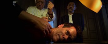 Movie still from “Elephant White” (2011), directed by Prachya Pinkaew – A man getting his head shaven while another man watches; Close Up shot, Over the shoulder angle