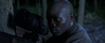 Movie still from “Elephant White” (2011), directed by Prachya Pinkaew – A man with a camera looking into the distance; Close Up shot, Low angle